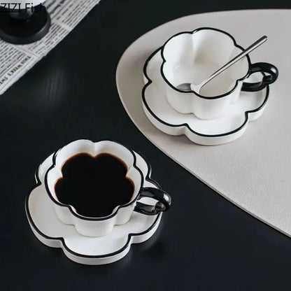 White ceramic mug set with black edged flower design and sleek black handles for kitchen use
