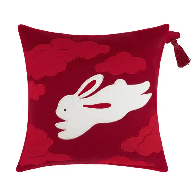 A plush red velvet bolster pillow cover featuring white embroidered rabbit and cloud motifs with bamboo leaves accents
