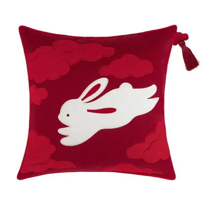 A plush red velvet bolster pillow cover featuring white embroidered rabbit and cloud motifs with bamboo leaves accents