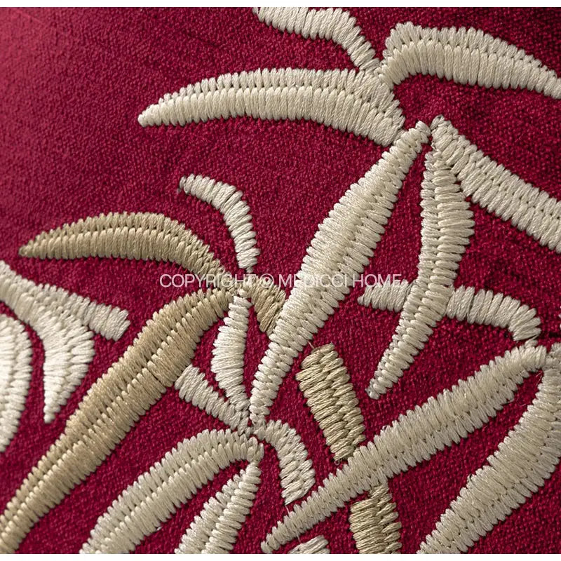 A plush red bolster pillow cover with intricate cream embroidered bamboo leaves for bedroom pillow covers
