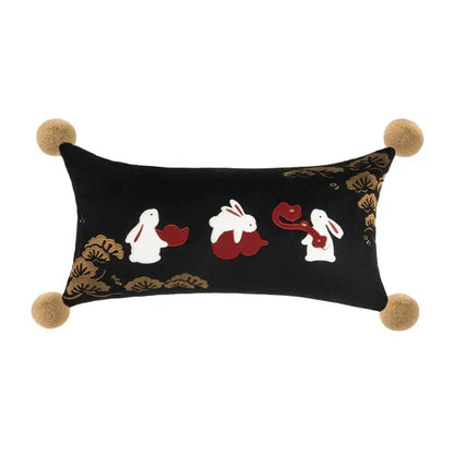 Black velvet bolster pillow cover with embroidered white rabbits red fans and gold bamboo leaves with tan pom-poms