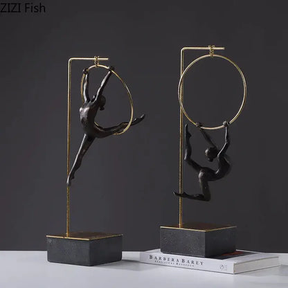 Black gold gymnastic acrobat resin sculpture with two black metal figurines in gold hoops on dark stone bases decorbites gymnastic acrobat