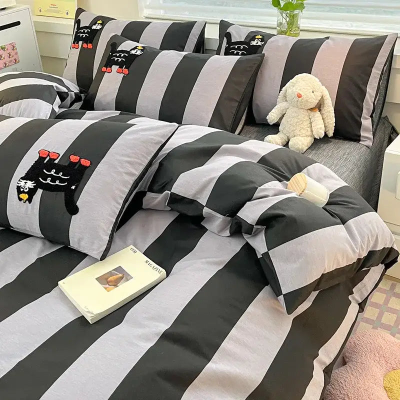Black and gray striped bedding set with playful black cat embroidery and red accents on pillows in bedroom bedclothes