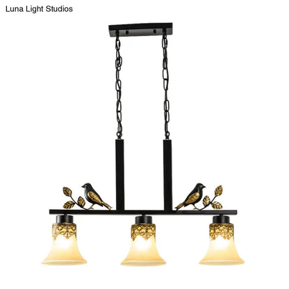 DecorBites black wrought iron island light pendant with gold bird motifs and three tan glass shades for dining room
