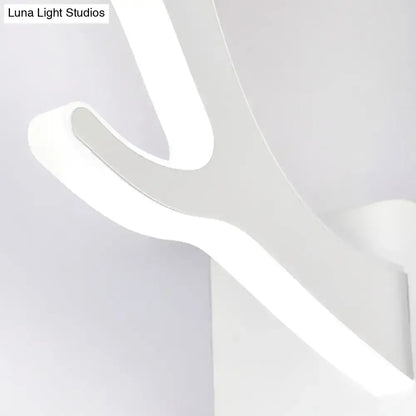 Modern white led wall sconce with sleek curved design as a metallic antler sconce wall mounted lighting fixture for bedroom