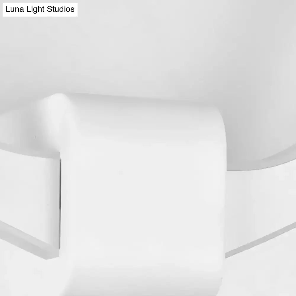 White ceramic toilet paper holder with smooth rounded edges paired with black metallic antler sconce wall mounted lighting