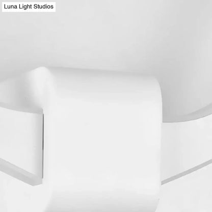 White ceramic toilet paper holder with smooth rounded edges paired with black metallic antler sconce wall mounted lighting