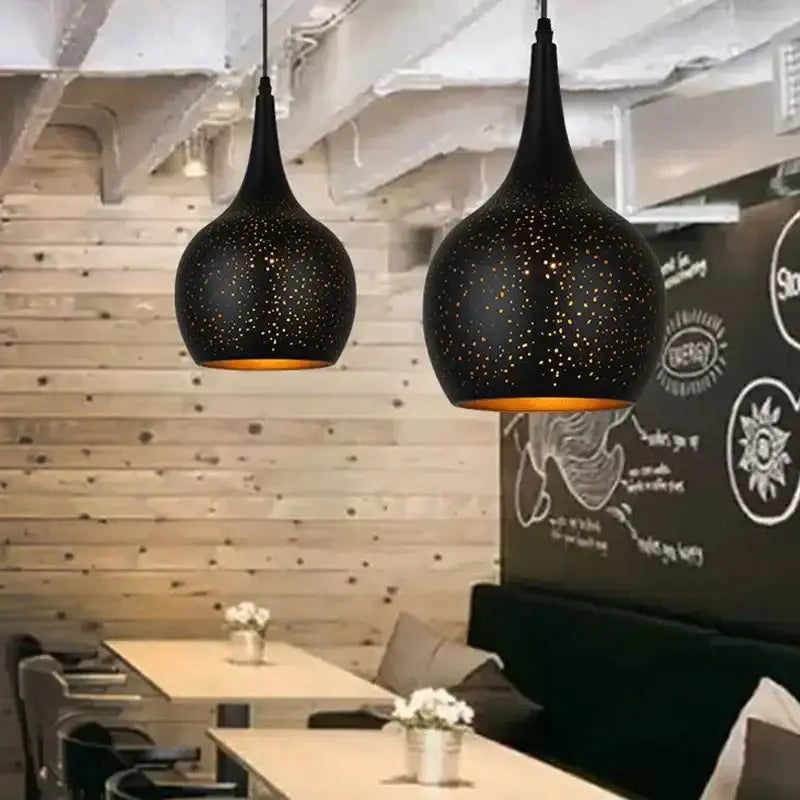 Black nordic industrial pendant light with speckled starry pattern and warm amber interiors for dining room decorbites