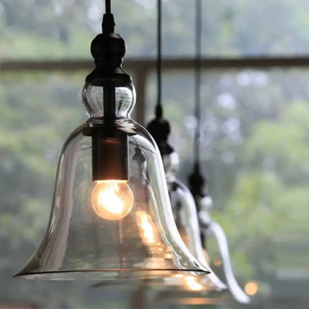 Clear glass bell-shaped pendant lamp with black rustic metal fixture and exposed bulb from DecorBites Aldhibah black rustic