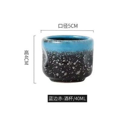A ceramic wine sake cup with gradient blue black glaze and white speckles in a black speckled ceramic wine sake set
