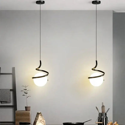 Two sleek black spiral cord pendant lights with frosted glass globes ideal for kitchen use under square meters