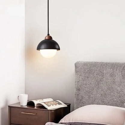 Black travertine pendant light with matte black dome shade brass accent emitting warm light decorbites glass ball