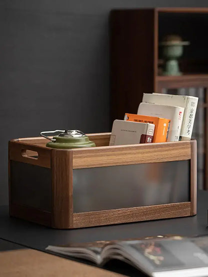 A black walnut wood desktop organizer with a translucent glass front and integrated handles holding books and a teapot