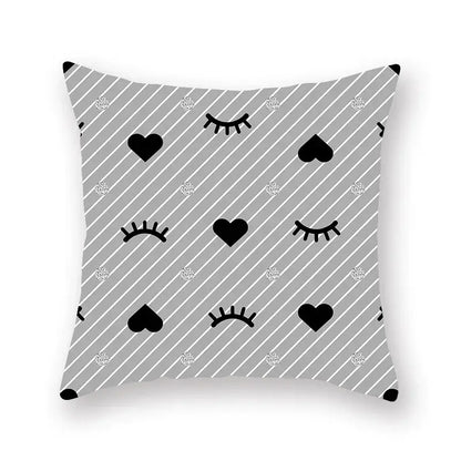 Gray throw pillow with black hearts closed eyes and silver glitter dots on a geometric star stripe print pattern