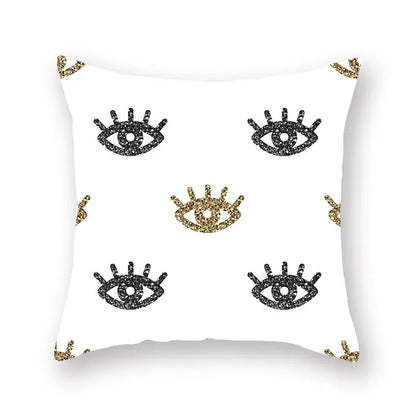 White throw pillow with black and gold glittery eye motifs featuring geometric star stripe print for bedroom decor