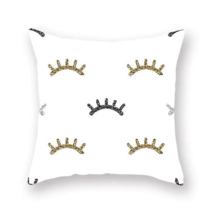 White throw pillow with glittery gold black and silver eyelash designs featuring geometric star stripe print decor