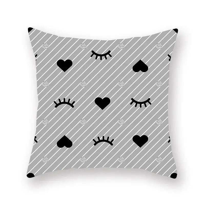 Gray throw pillow with black hearts and closed eyes on a geometric star stripe pattern with silver glitter dots for décor