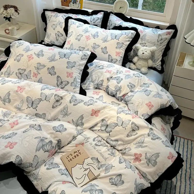Butterfly-patterned bedding set with black white printed floral design and black ruffled edges on soft cream fabric by decorbites black white