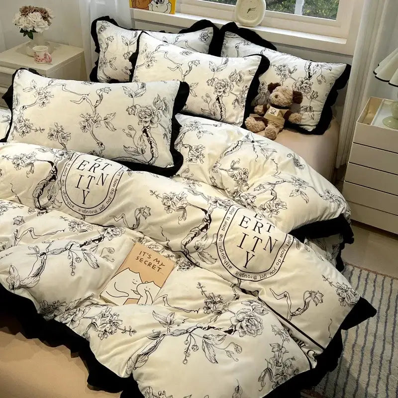 Cream-colored decorbites black white printed bedding set with black floral embroidery ruffled edges and eternity design