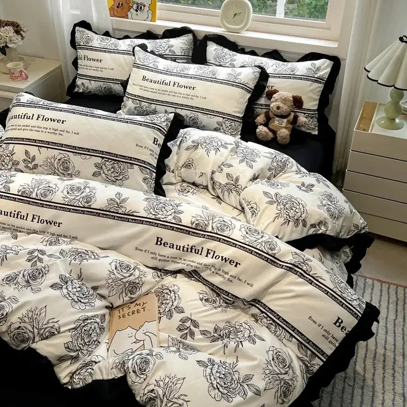 Cream-colored decorbites black white printed bedding set with black floral patterns and ruffled edges for bedroom linens
