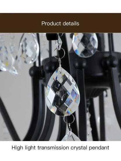 Clear faceted teardrop crystal pendant with high light transmission on black wrought iron chandelier for dining room