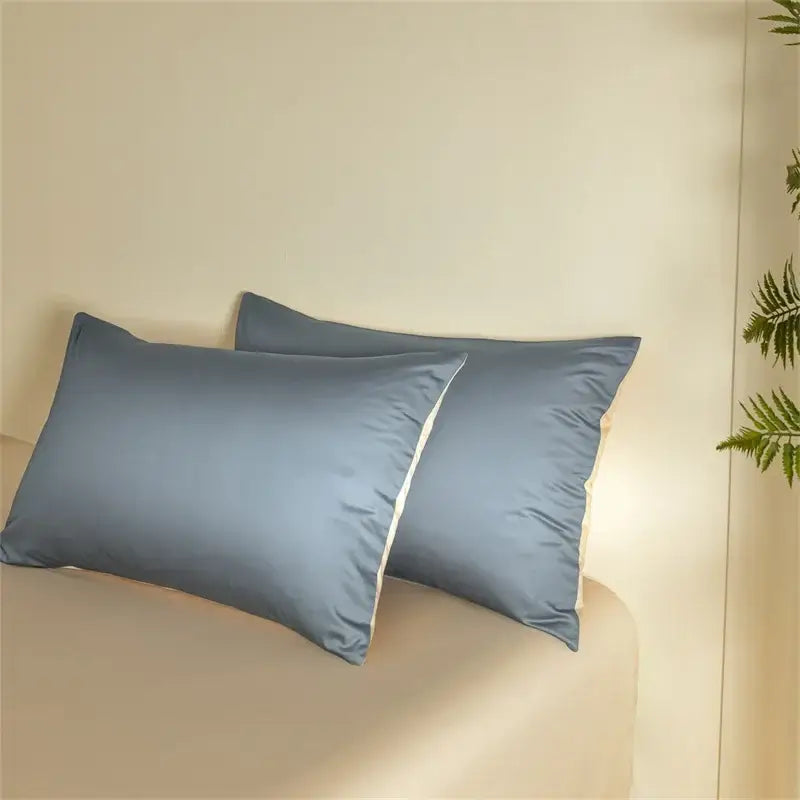 Two soft dusty blue pillowcases with white piping in a blue and beige egyptian cotton bedding set for bedroom