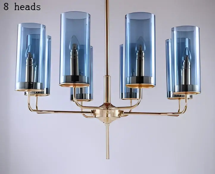 Blue and gold decorbites glass chandelier featuring a blue glass cylinder and brass accents for kitchen island lighting