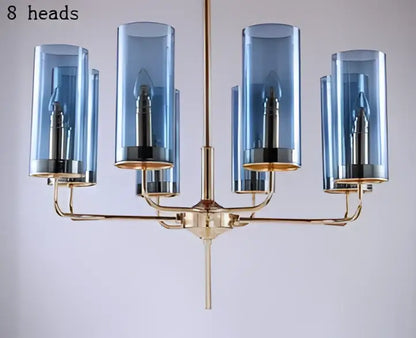 Blue and gold decorbites glass chandelier featuring a blue glass cylinder and brass accents for kitchen island lighting