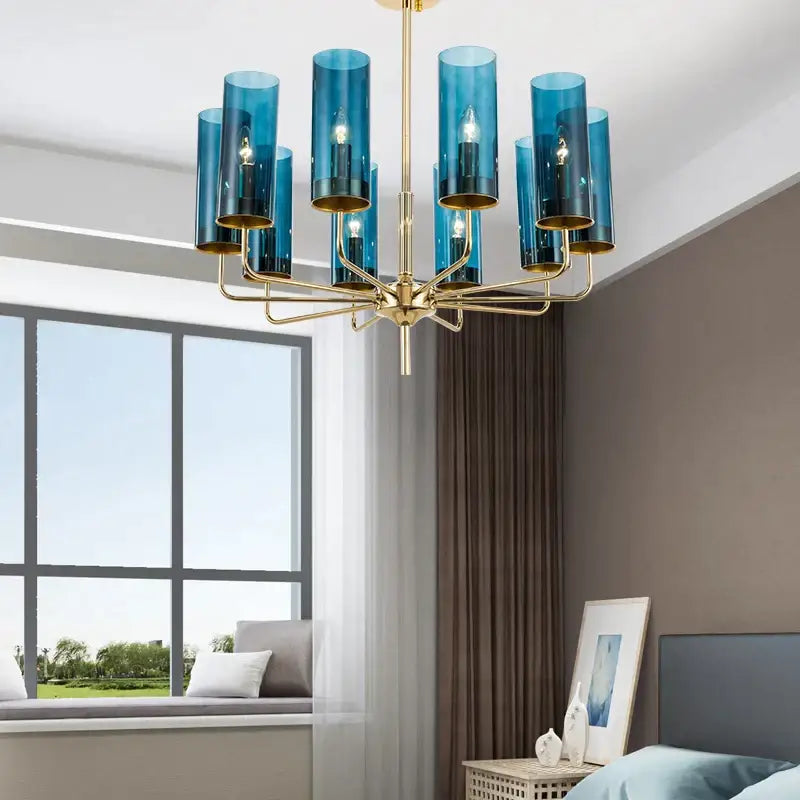 Blue and gold decorbites glass chandelier featuring cylindrical glass shades and a metal frame for kitchen island lighting