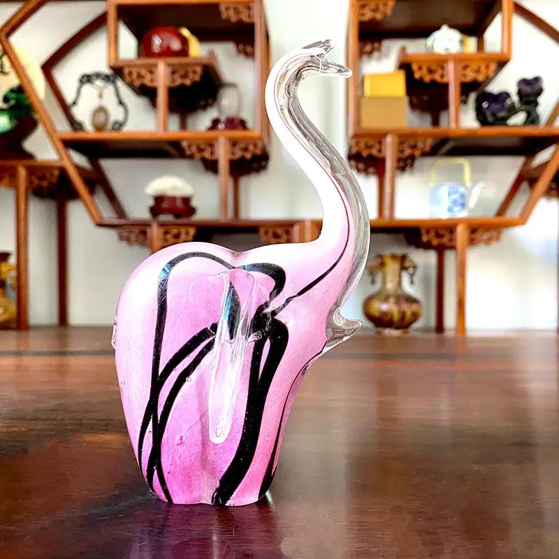 Translucent pink crystal glass elephant sculpture with black swirls and a clear curved trunk for living room decor