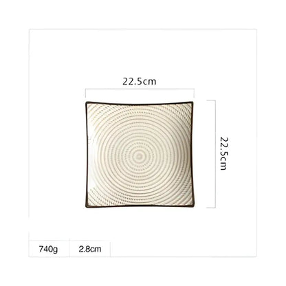 Square woven cushion with beige and dark brown concentric pattern displayed next to blue and white porcelain square dinner plate