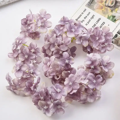 A cluster of decorbites hydrangea flowers in soft lavender and pale purple hues with white centers for wedding decor