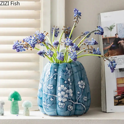 A blue white porcelain pumpkin vase with white floral and butterfly patterns ideal for living room decor