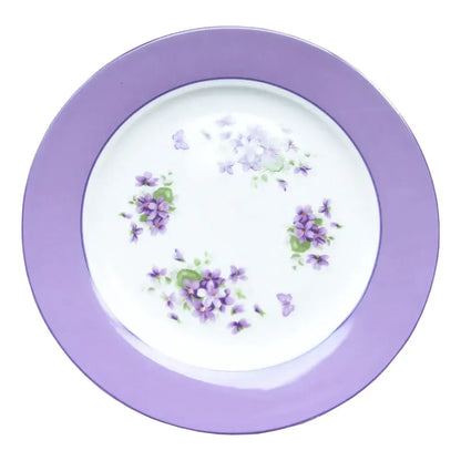 A delicate white porcelain plate with a lavender rim and hand-painted violets from the blue dream tea set
