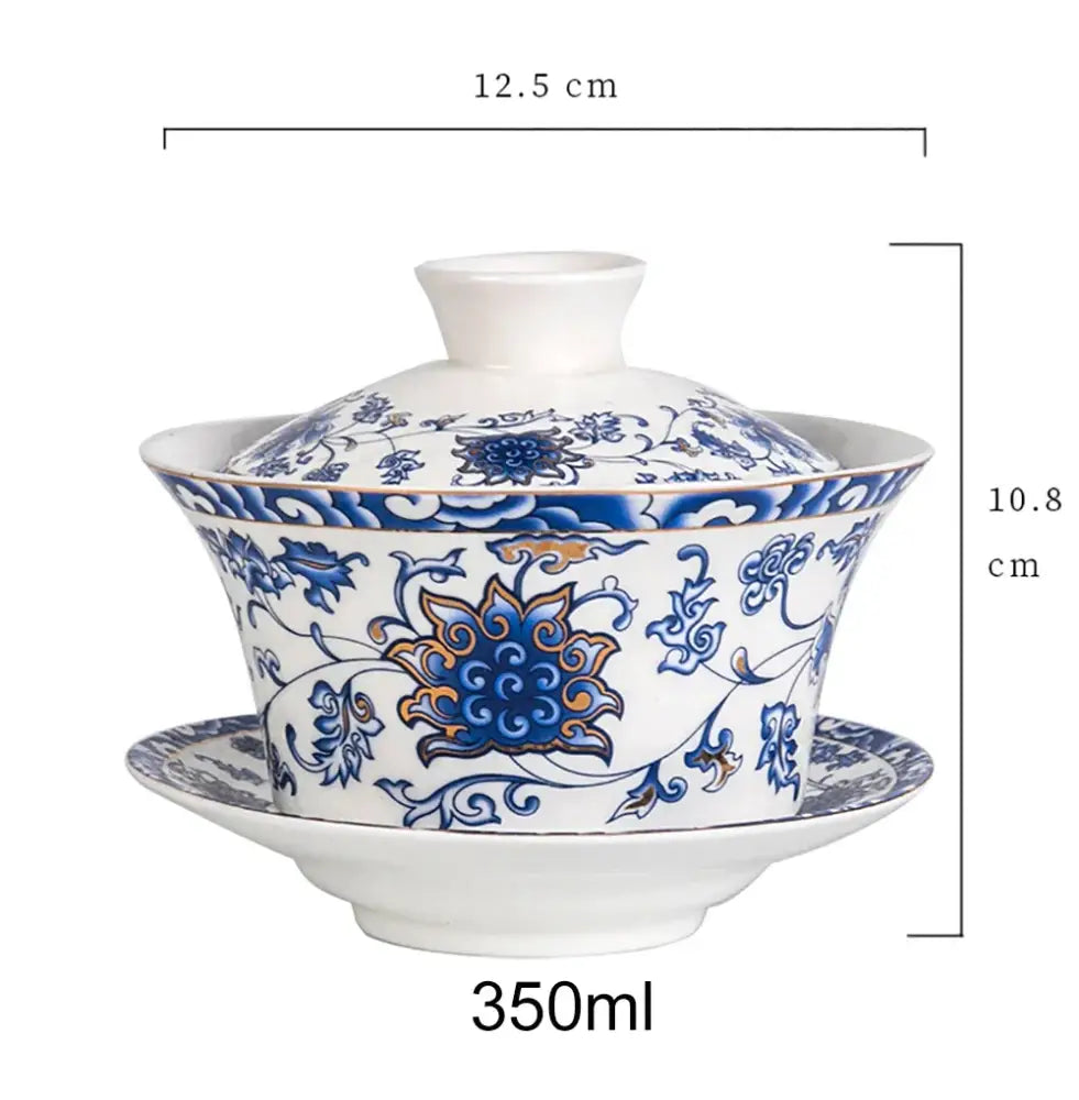A white porcelain tea cup set with blue and gold floral design featuring an ornate lid and matching saucer for dining room