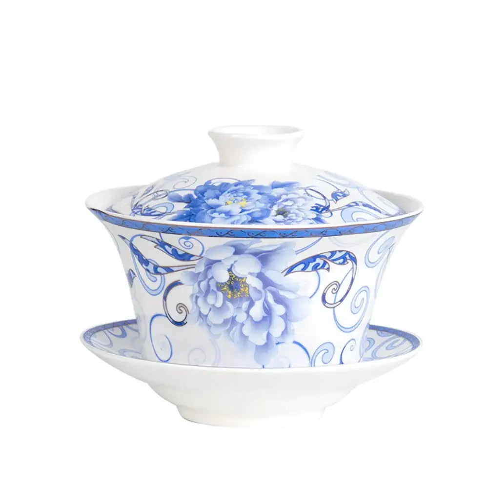A white porcelain tea cup set with blue floral patterns including peonies on a teapot and matching saucer