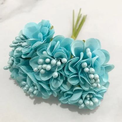 A bundle of light blue flower stamen berries with fabric petals and pearl details for kitchen cake decor