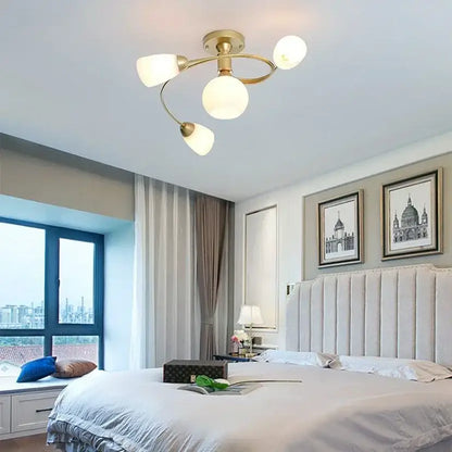 Gold-toned dining room ceiling light with three frosted glass ball led shades and curved metallic arms decorbites glass ball