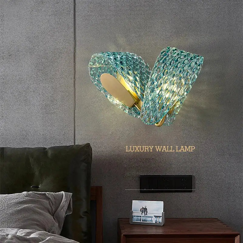 A teal textured glass wall lamp with a gold-toned metal base for decorbites blue glass flower ceiling decor