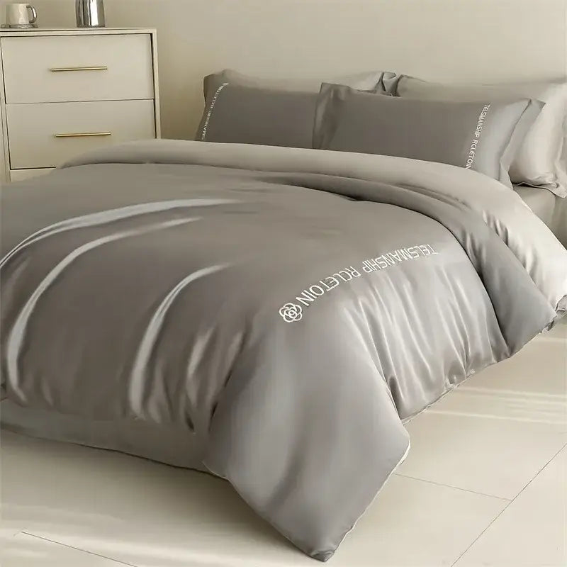 Gray satin duvet cover with white embroidered text and logo from decorbites cotton solid color bedding set