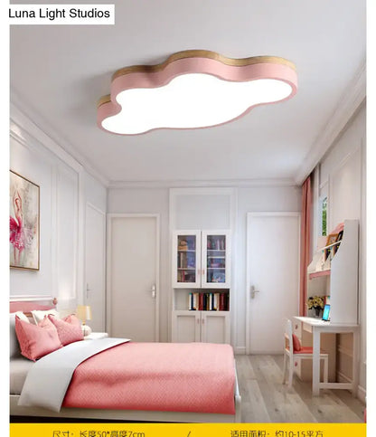 Pink flush mount ceiling lamp shaped like a cloud with wooden trim designed for kids bedroom lighting