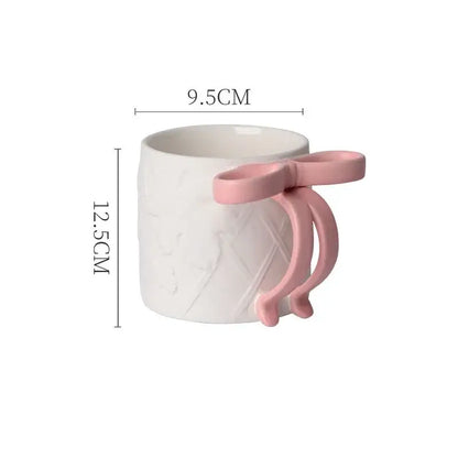 A white ceramic bowknot ceramic mug with a pink bow-shaped handle and subtle diamond texture from decorbites saucer set