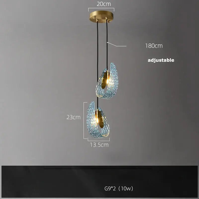 A modern decorbites blue queen pendant light with two teardrop textured blue queen crystal glass shades and brass finish