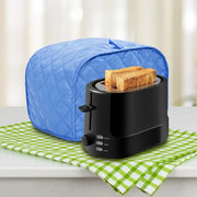 Black toaster with blue cover and two slices of toast on a green checkered towel.