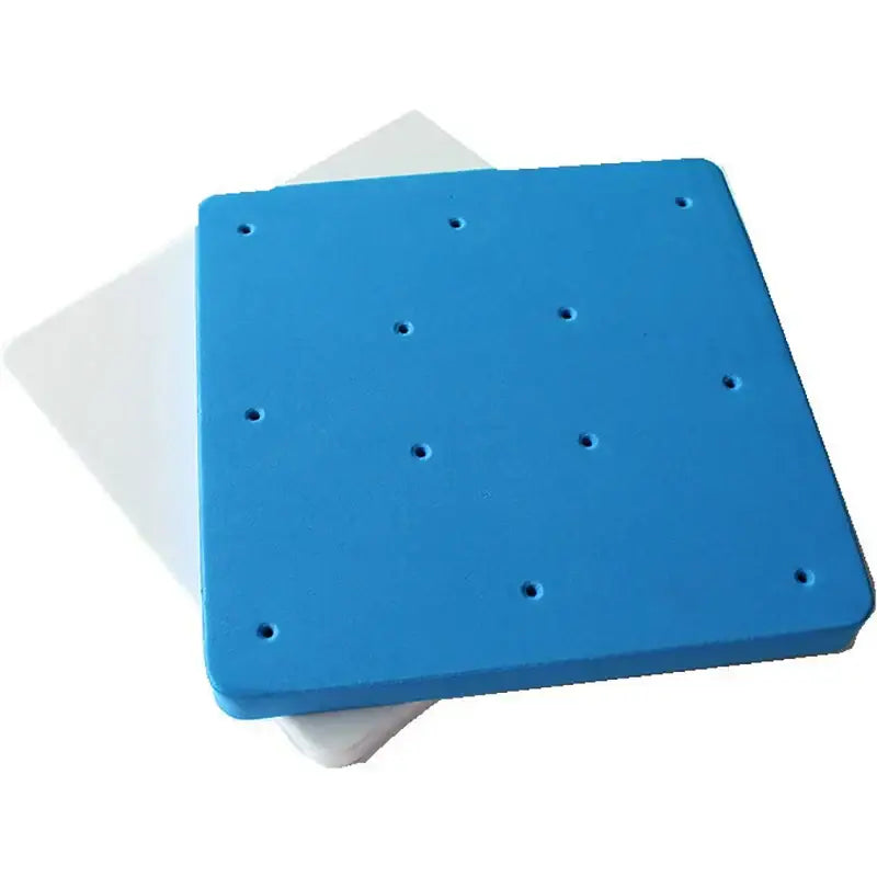 Blue square foam cake shaping mat with evenly spaced circular indentations for precise cake shaping in the kitchen