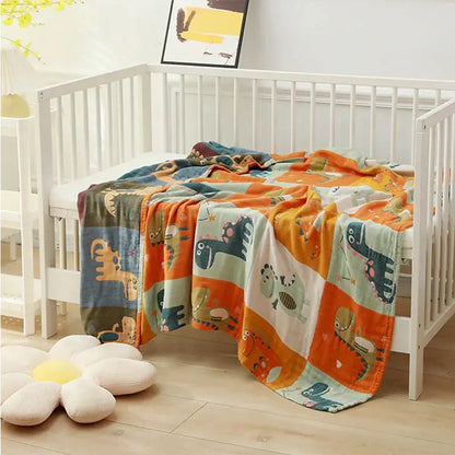 A soft plush cotton bath towel blanket in teal cream and orange with colorful cartoon dinosaur patchwork design