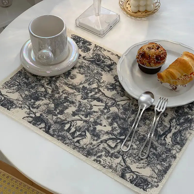 Beige cotton linen meal mat with black and white forest scene print and frayed edges from decorbites cotton linen collection