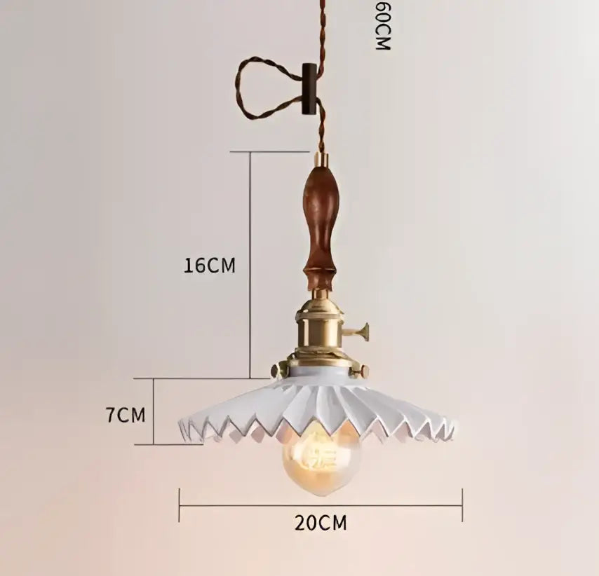 Vintage-style decorbites pendant light with brass fixture, wooden handle, and white ceramic scalloped shade for bedroom decor
