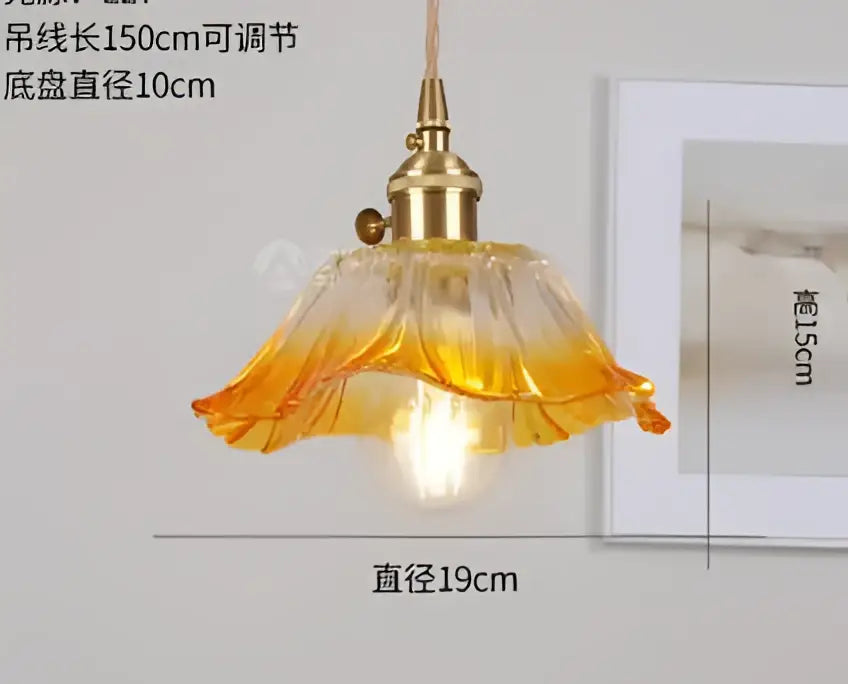 A warm-toned amber glass pendant light with brass fixture and petal design by decorbites pendant lights for bedroom decor