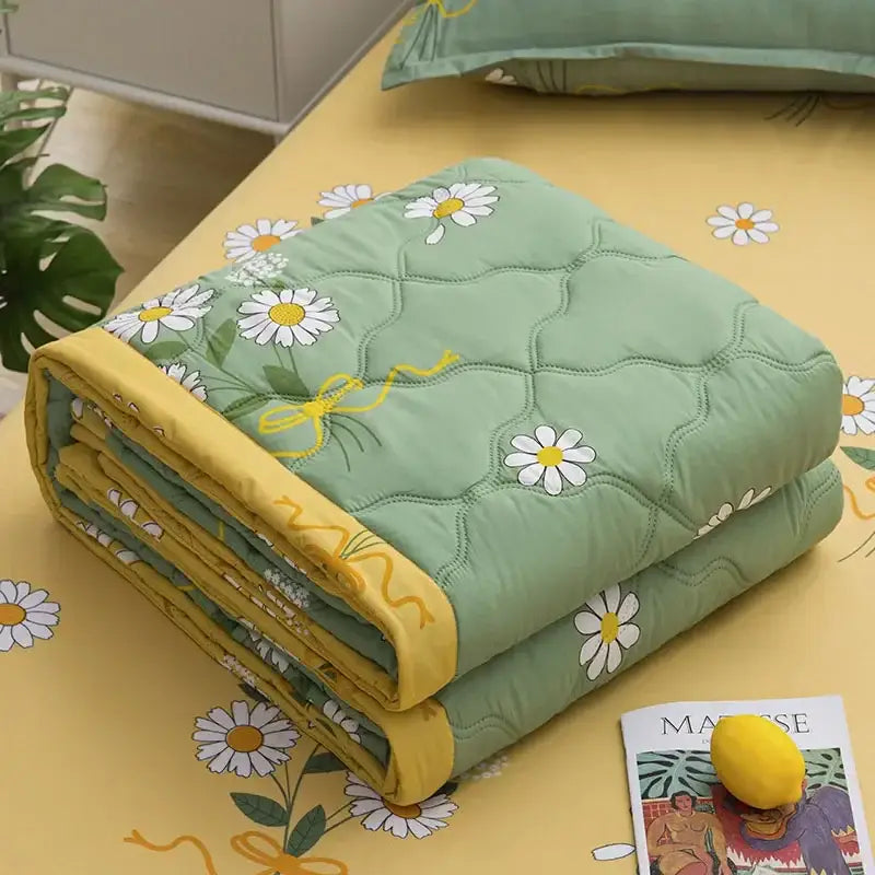 A soft mint green decorbites daisy print quilt with yellow trim and diamond quilting for bedroom decor